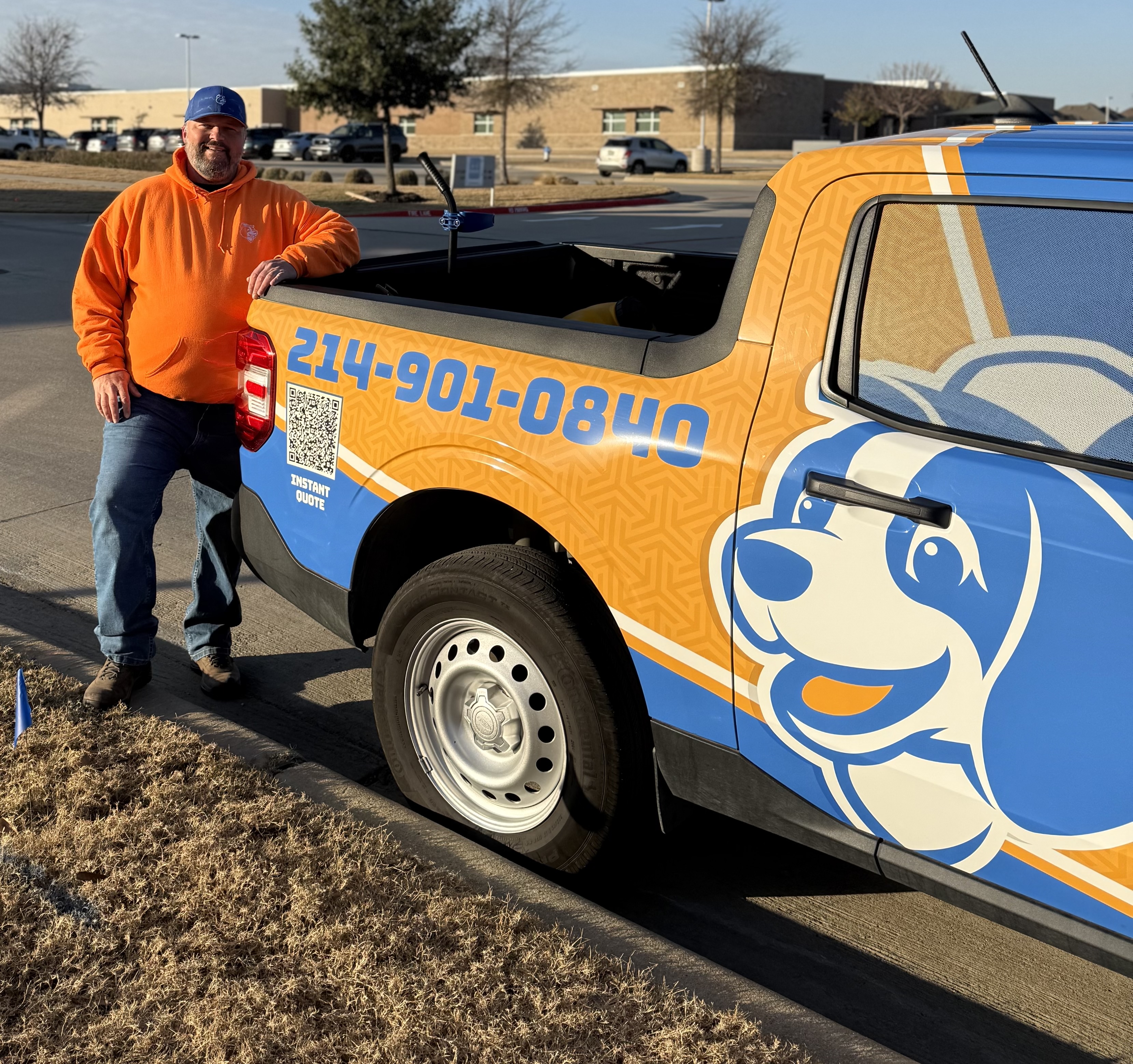 Ryan White, founder of Doodie Crew, standing next to the branded service truck in Prosper, TX